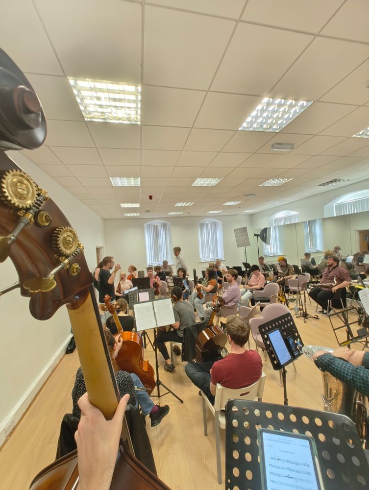 A happy orchestra filling a rehearsal hall again