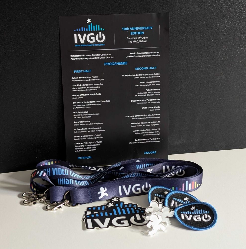 Irish Video Game Orchestra concert program with lanyards, badges, pins, and stickers below