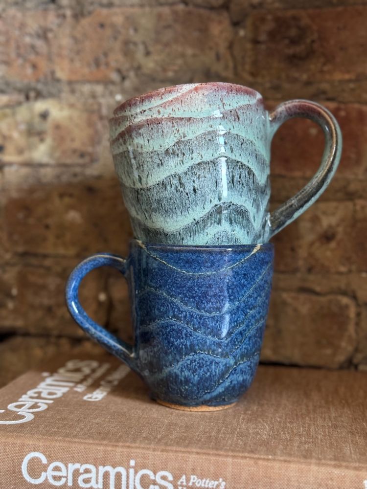 2 Stacked Mugs. Bottom Blueish and top greenish