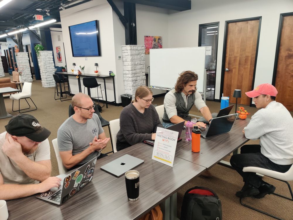A group of five people working heads down on the Greeting kata