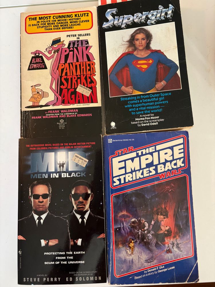 Paperback novelizations of The Pink Panther Strikes Again, Men in Black, and The Empire Strikes Back.