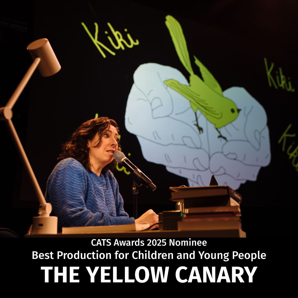 Image of a performers sat behind a desk, speaking into a microphone with a screen behind with a large canary. White text of the name of the show underneath.
 
