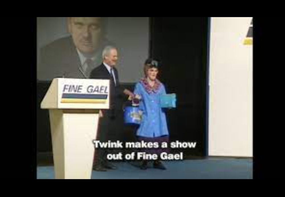 John Bruton on stage at the party Ard Fheis with Twink. Caption "Twink makes a show out of Five Gael"