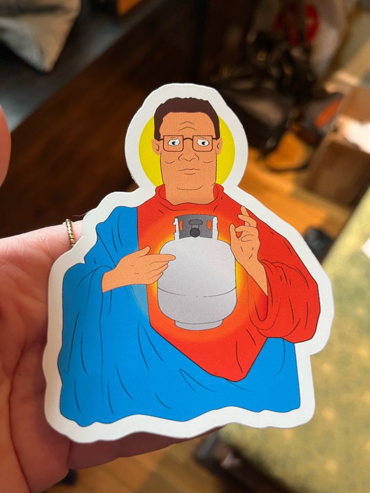 A sticker of Hank Hill holding a propane tank but rendered as holy like a saint or perhaps Christ.