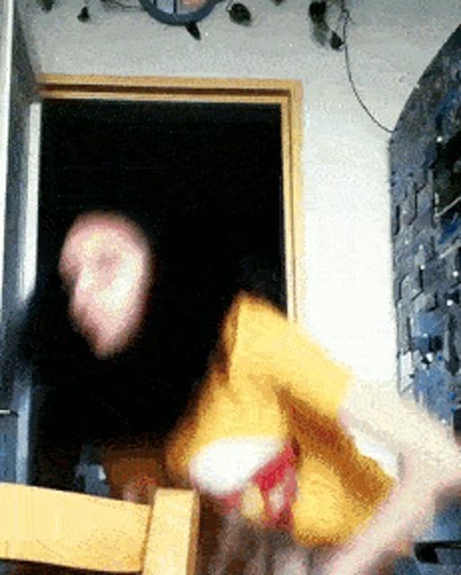 a blurred image of a person in a yellow shirt