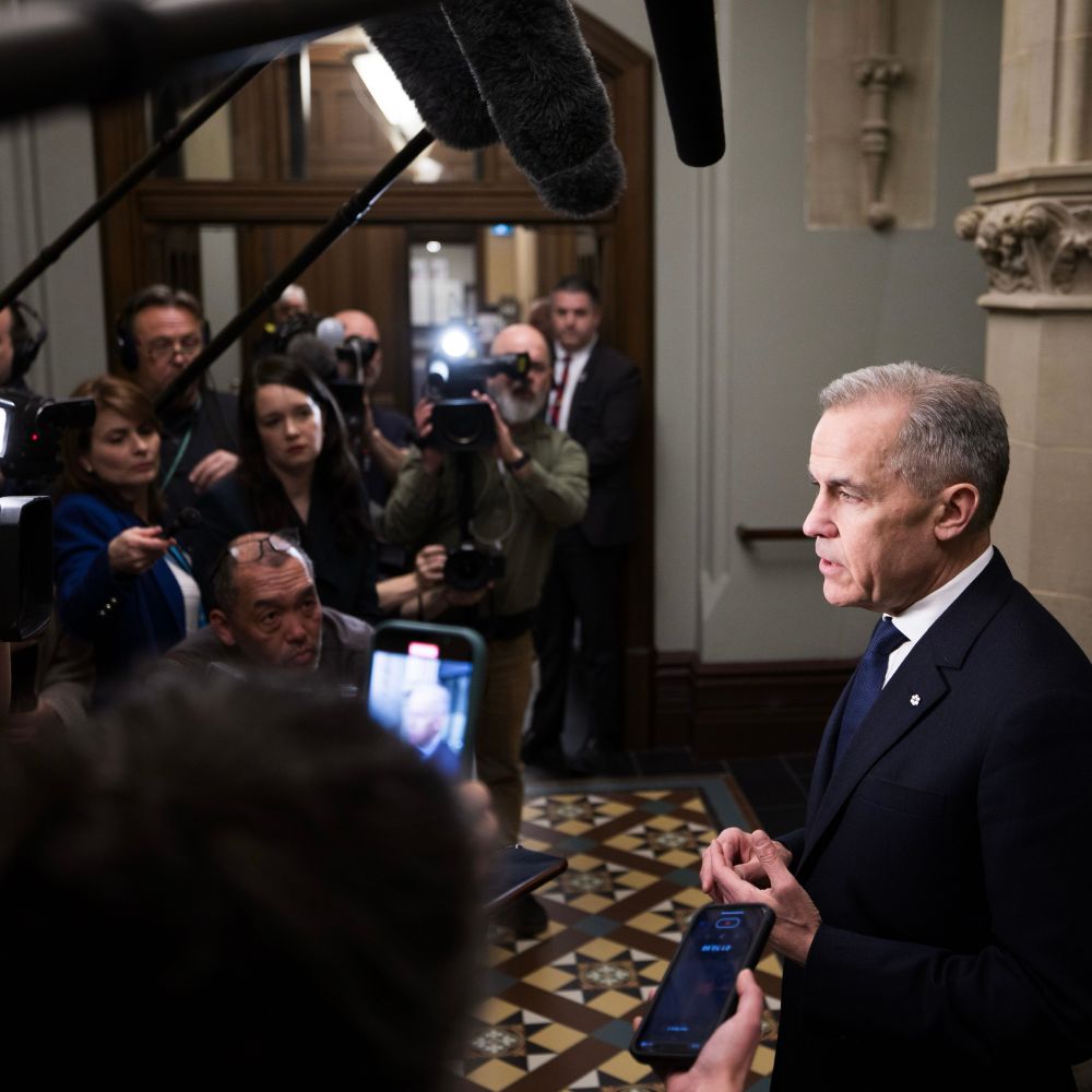 Prime Minister Mark Carney answers questions from reporters during a scrum at West Block, in Ottawa, Ontario.