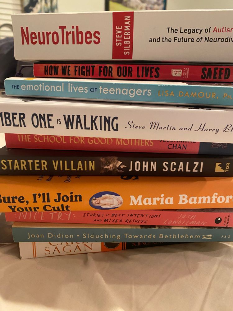 A stack of wonderful books: NeuroTribes, How We Fight for Our Lives, The Emotional Life of Teenagers, Number One Is Walking, The School for Good Mothers, Starter Villain, Sure I’ll Join Your Cult, Nice Try, Slouching Toward Bethlehem, and The Demon-Haunted World. Too many long titles!