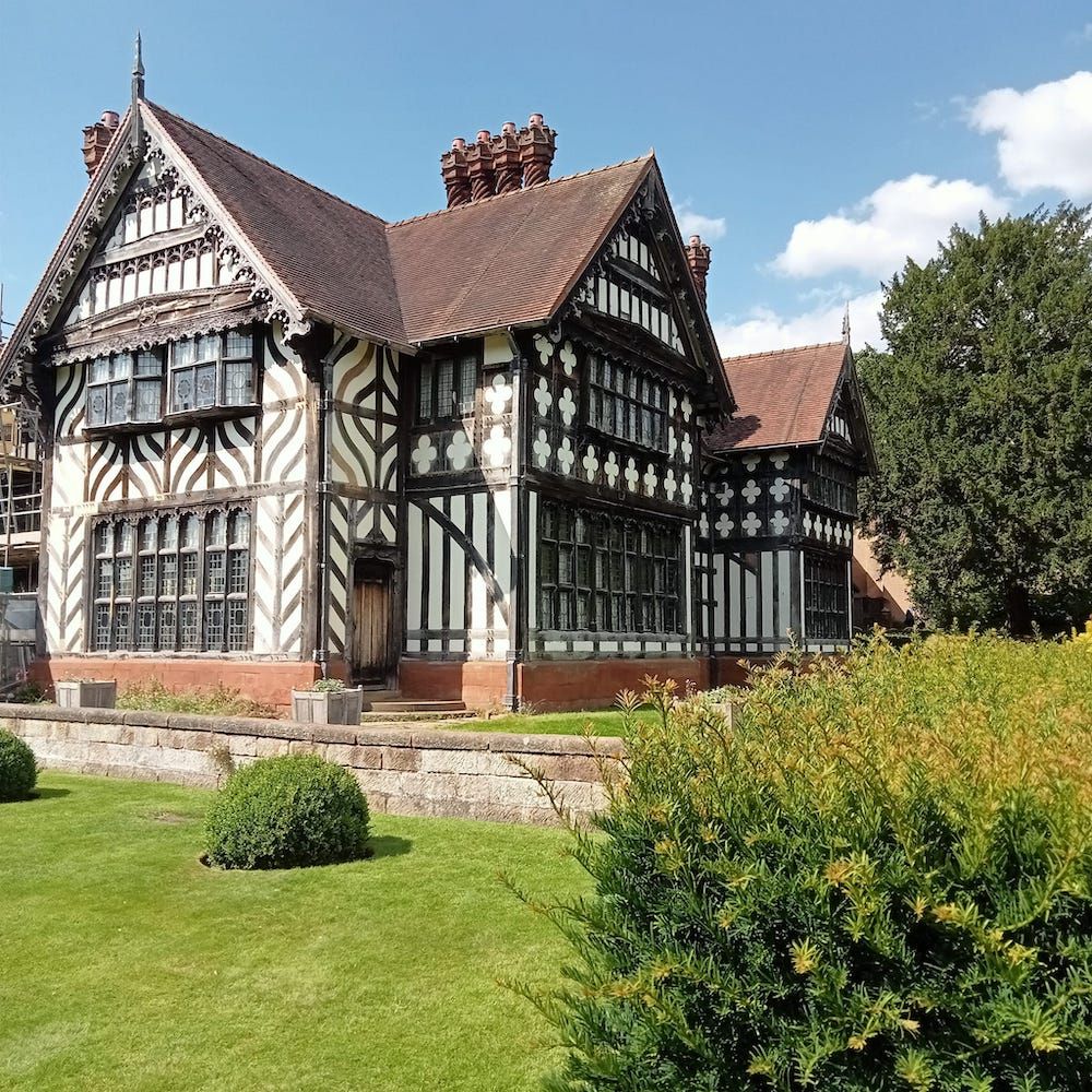 
Lots of timber on the exterior, and decorative bargeboards, mullioned windows and barley-sugar chimney pots--vernacular revival with a vengeance!
