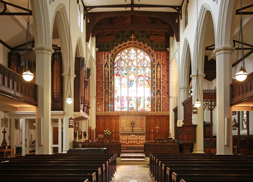 Spacious interior of the nave looking towards the chancel and the impressive stained glass E Window.
