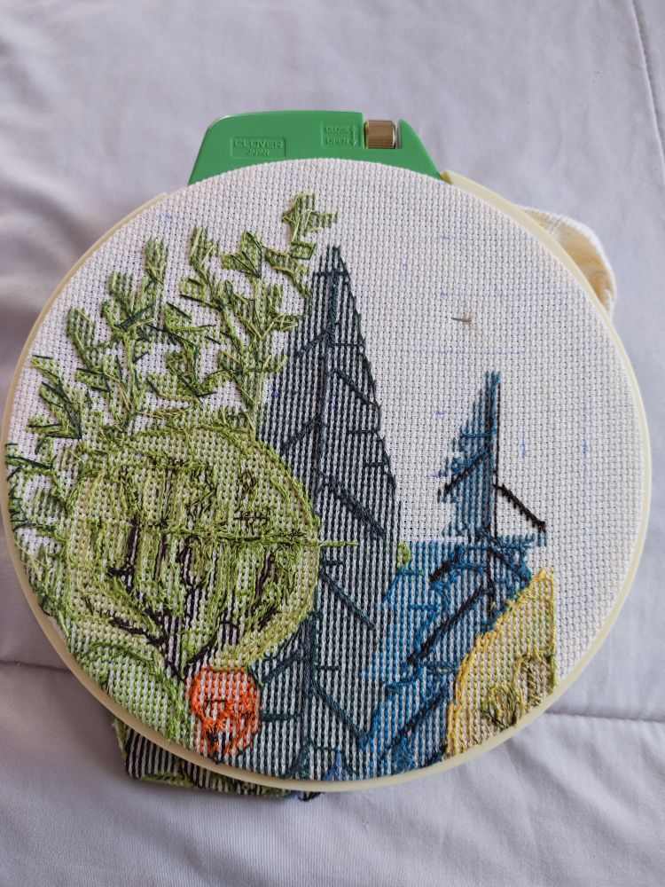 Back of crossstitch project with green trees and leaves