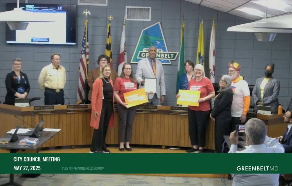 Screenshot of the Greenbelt City Council meeting on May 27. Councilmembers and mayor are standing behind the dais with 5 people from Moms Demand Action posing for a photo in front of them.