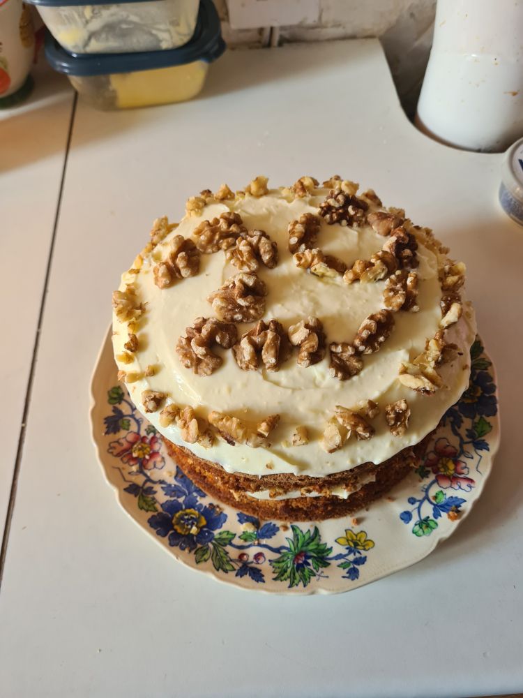 Carrot cake with cream cheese frosting and walnuts in the shape of the number 29 on top 