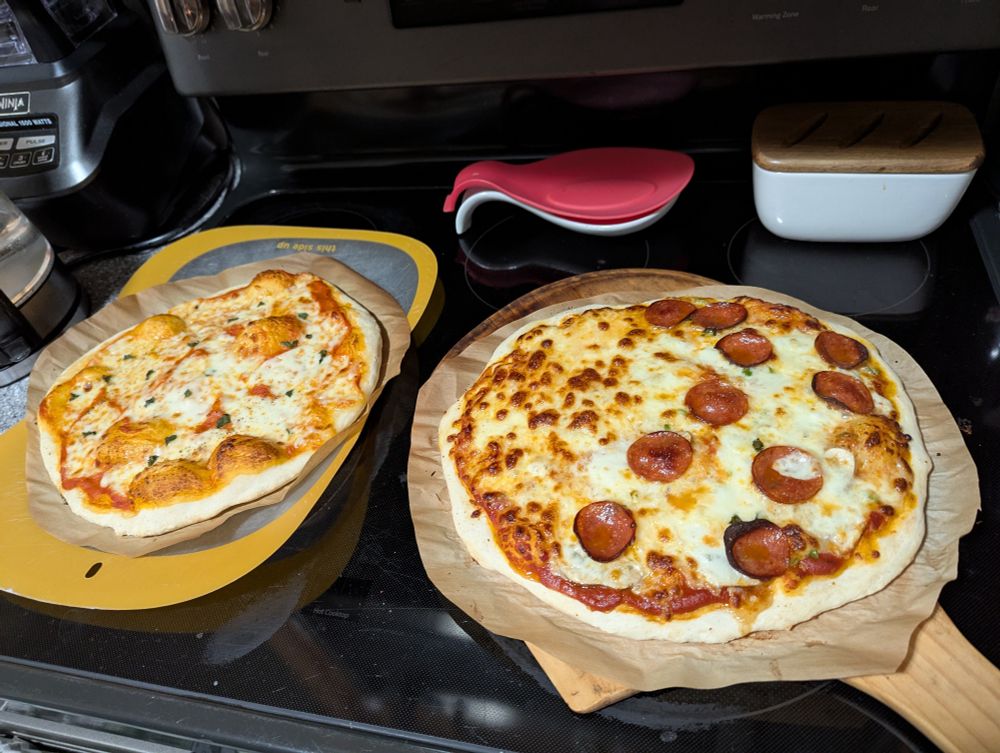 Two pizzas, a traditional margherita and a pepperoni and mushroom