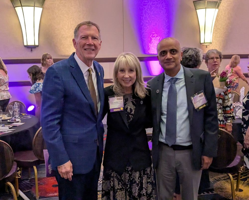Former Rep. Jon Porter, Kristin McMillan Porter, and DRI President Kumud Acharya in a ballroom.