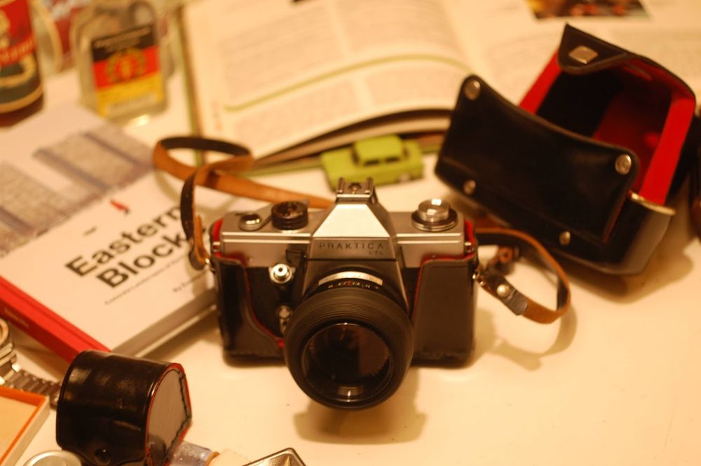 Praktica SLR surrounded by some GDR paraphernalia invluding a model Trabant, Vergessenheitstrunk and the book Eastern Blocks