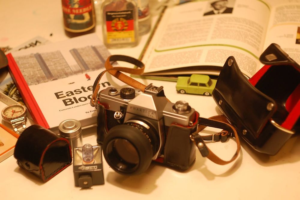 Praktica SLR surrounded by Eastern Block paraphernalia, as well as accessories that were bought with the camera 50 years ago. A nice plastic cover, an adapter for a telelens, a reusable film container and a flashholder (there are still half a dozen flashbulbs left, because it was later replaced by an electrical flashlight)