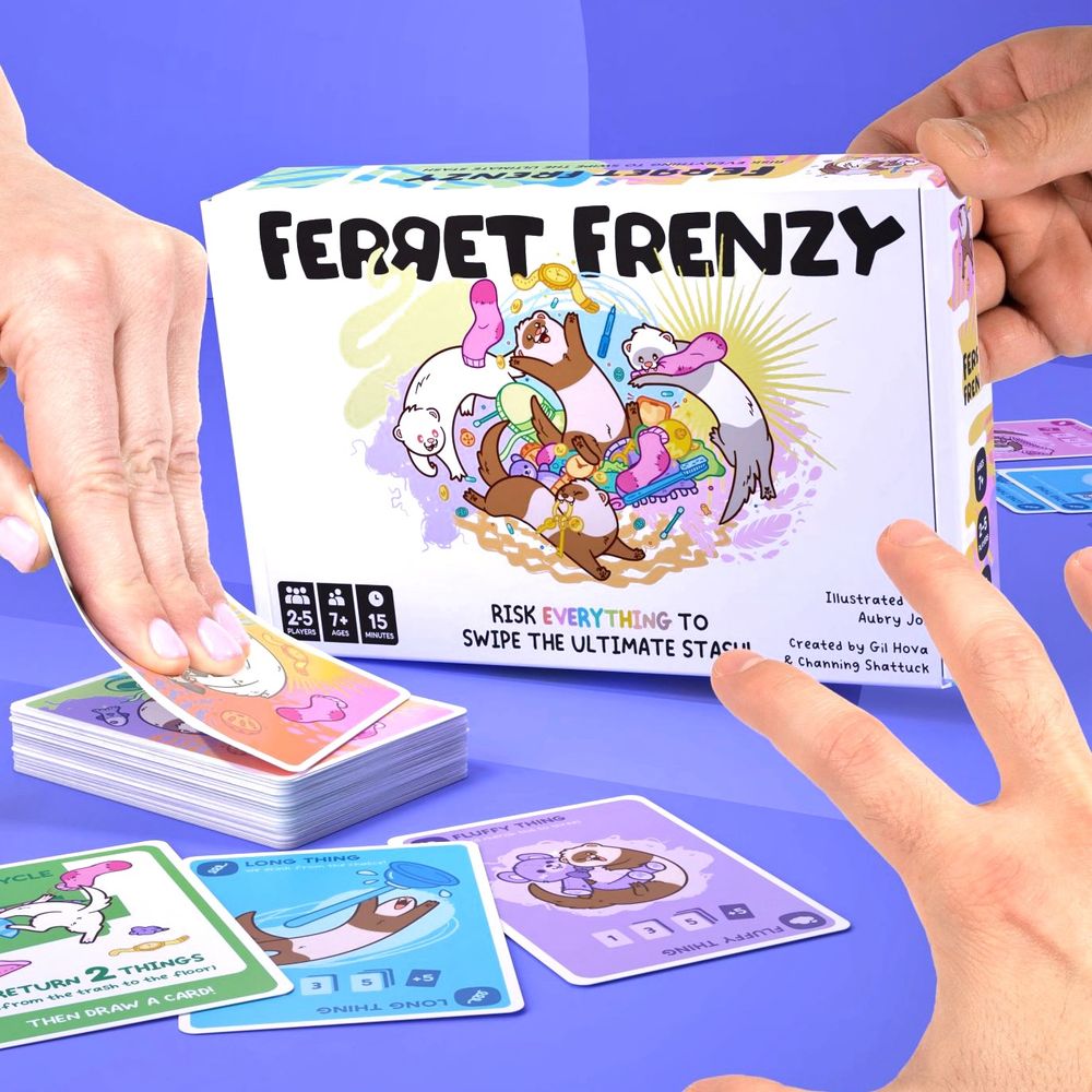 A photo showing the box art for Ferret Frenzy, a ferret-themed card game. The artwork shows ferrets running around and playing in a pile of various household items in a rainbow of colors. Several hands are reaching in and grabbing cards as if playing the game.