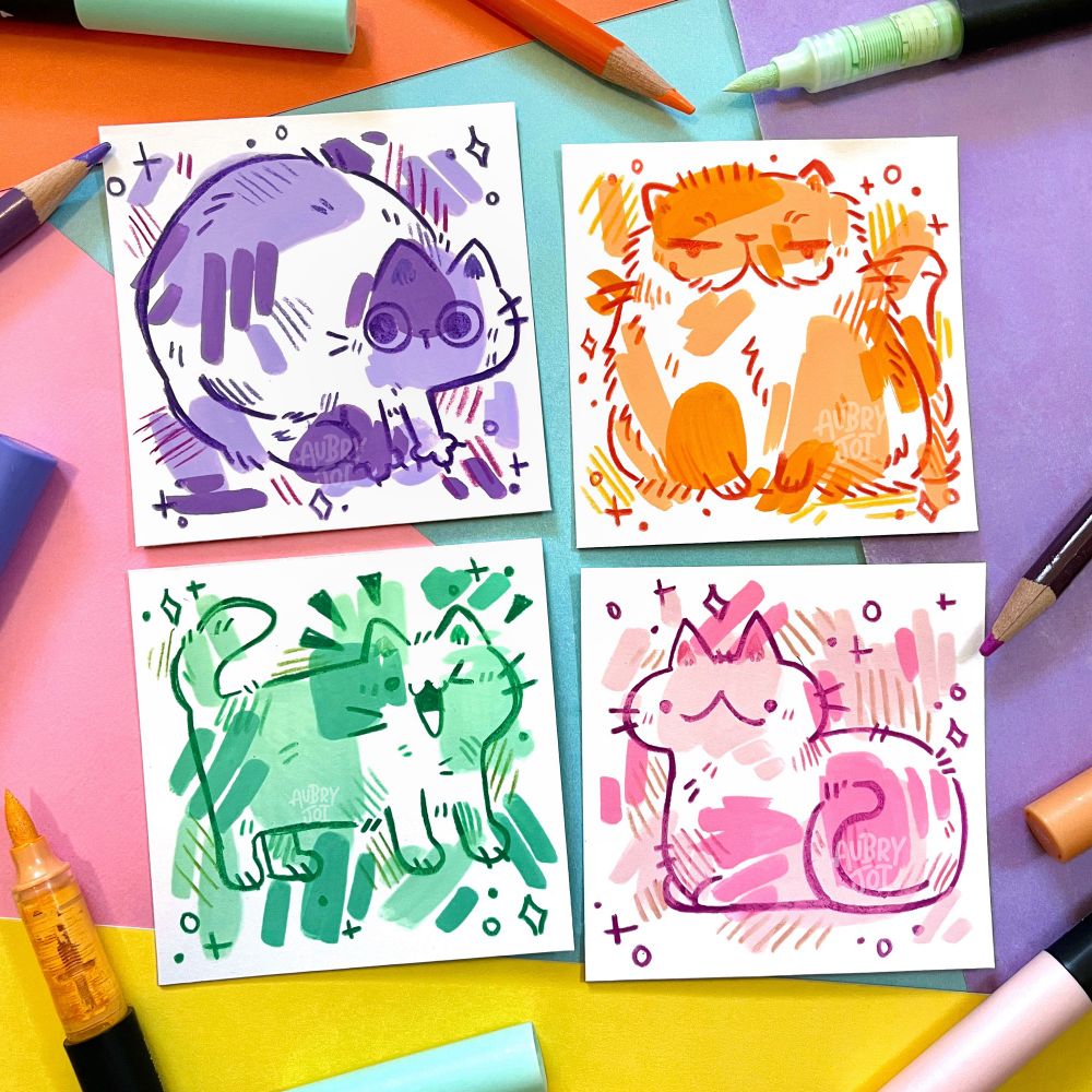 Four sketchy doodle illustrations of cats made up of brush pen marks and colored pencil outlines. They’re each made up of shades of a different color: purple, orange, teal, and pink.
