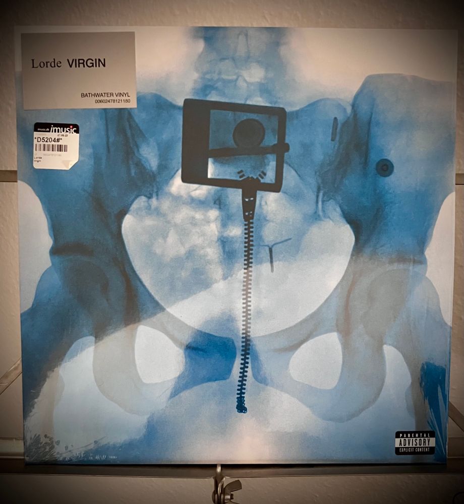 Lorde Virgin Albumcover Frontseitiges Röntgenbild des Beckens inklusive Gürtelschnalle und Reissverschluss. O. l. Aufkleber Albumtitel und kleiner Aufkleber des dänischen Händlers iMusic. 