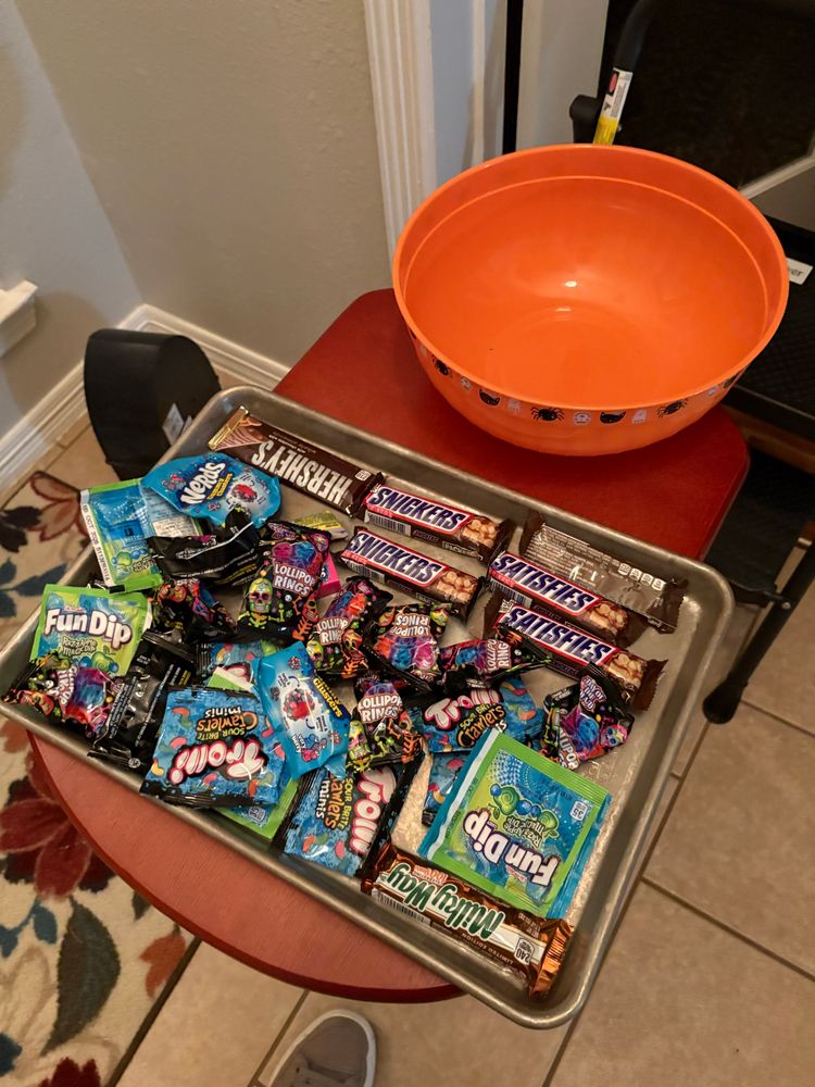 Remaining tray of Halloween candy: five snickers bars, one Hershey bar, with almond, one Milky Way, and an assortment of fun, dip, gummy, worms, and ringing pops.
