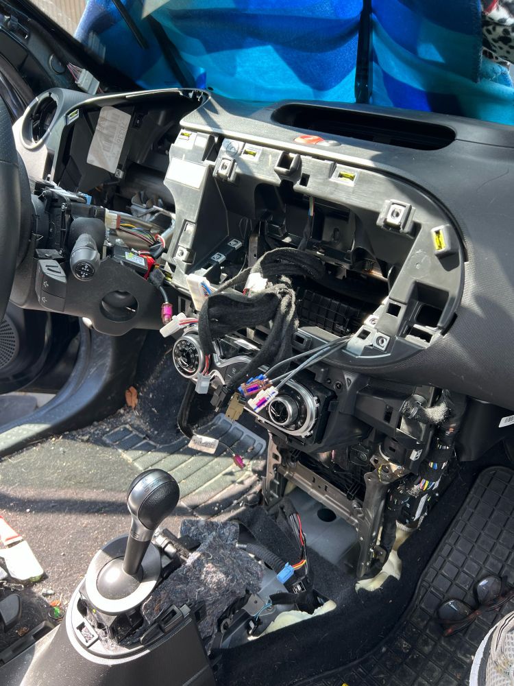 Das Cockpit eines Autos, komplett zerlegt, keine Anzeige, kein Handschuhfach, nur Drähte und leere Fächer.