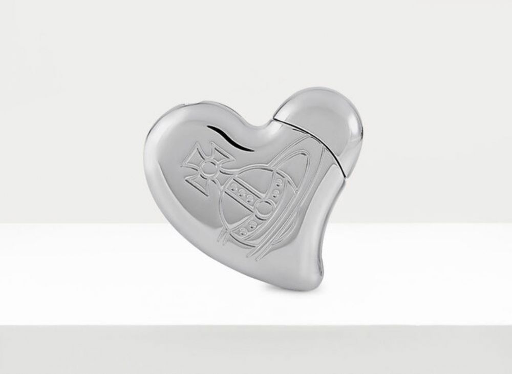 A heart shaped silver lighter with the Vivienne Westwood orb on it 