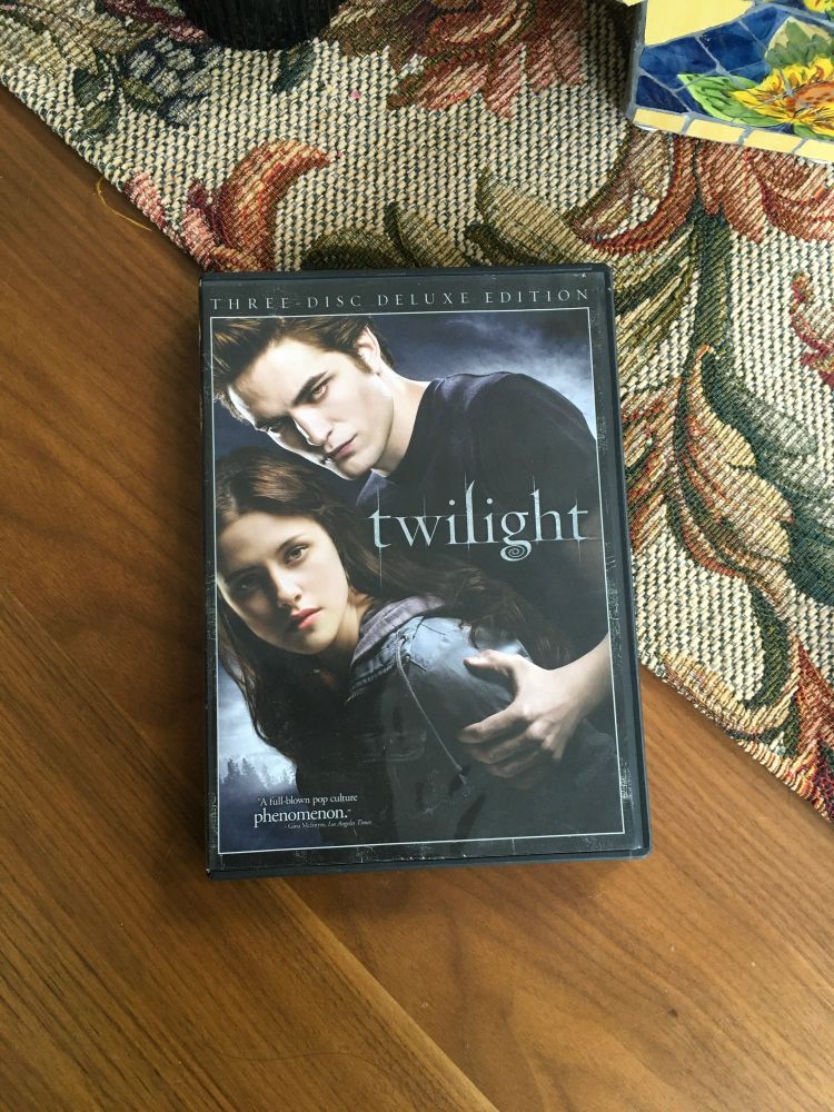 The DVD of Twilight. It features a brown haired girl and a brown haired boy in front of foggy trees 