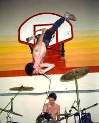 Guy Picciotto of Fugazi hanging from a basketball hoop