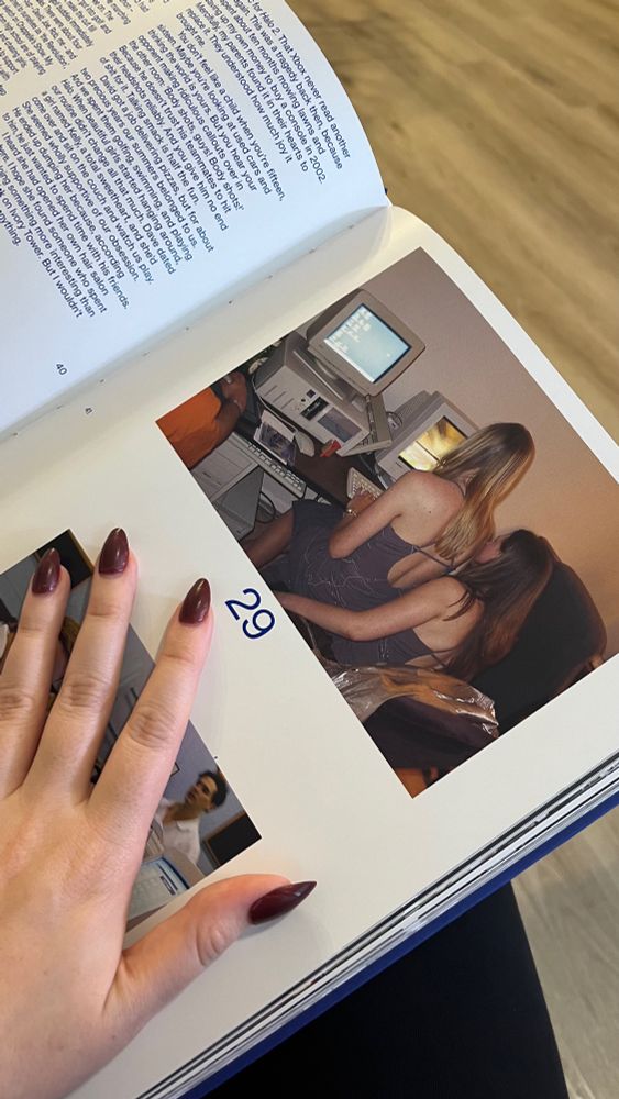 Photo of an open page of LAN Party marked "29," one computer user sits ont he other's lap (sapphically