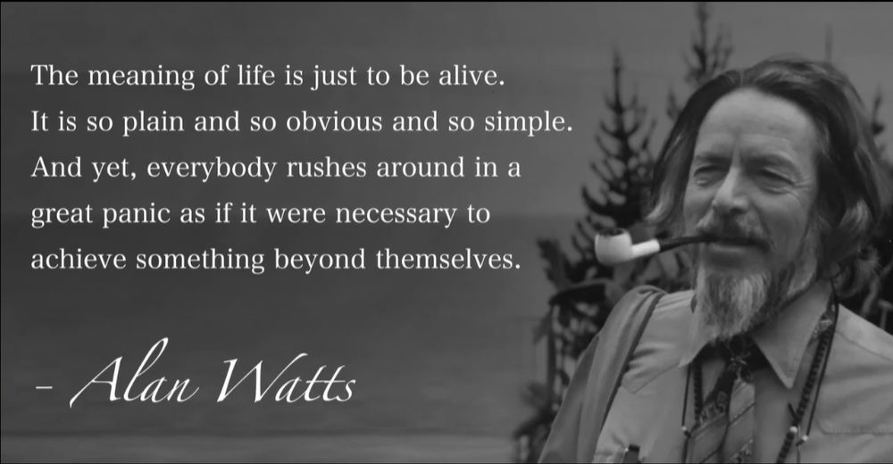 The image features a grayscale photograph of a person with a blurred face, wearing a shirt and tie, and holding a pipe. The background shows trees and a body of water. Overlaid on the image is a quote attributed to Alan Watts. The quote reads:

"The meaning of life is just to be alive. It is so plain and so obvious and so simple. And yet, everybody rushes around in a great panic as if it were necessary to achieve something beyond themselves."

- Alan Watts