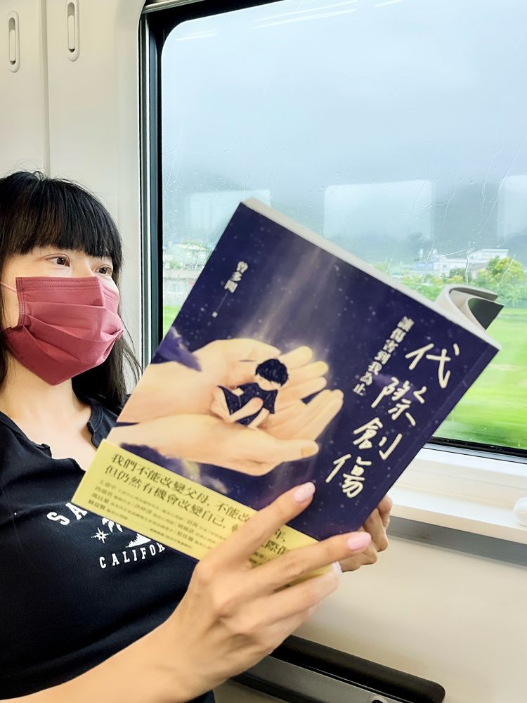 Woman reading by train window.