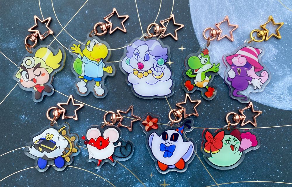 A lineup of acrylic charms on a starry background with a moon, featuring characters from Paper Mario the Thousand Year Door. The top row is Goombella, Koops, Madame Flurrie, Yoshi Kid, and Vivian. The second row is Admiral Bobbery, Ms. Mowz, Doopliss, and Lady Bow.