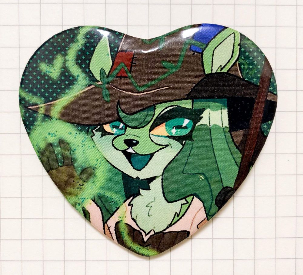 A photo of a heart shaped button featuring Sophie the Swamp Witch from Neopets.