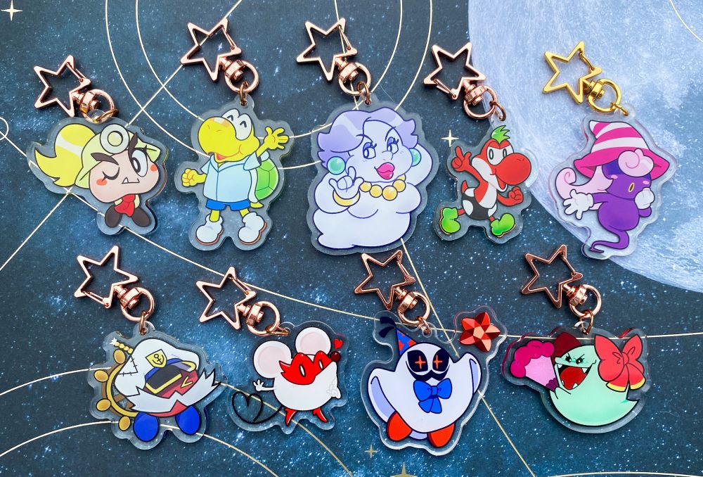 A lineup of acrylic charms on a starry background with a moon, featuring characters from Paper Mario the Thousand Year Door. They are the same charms as the previous image, but now flipped over to display different expressions.