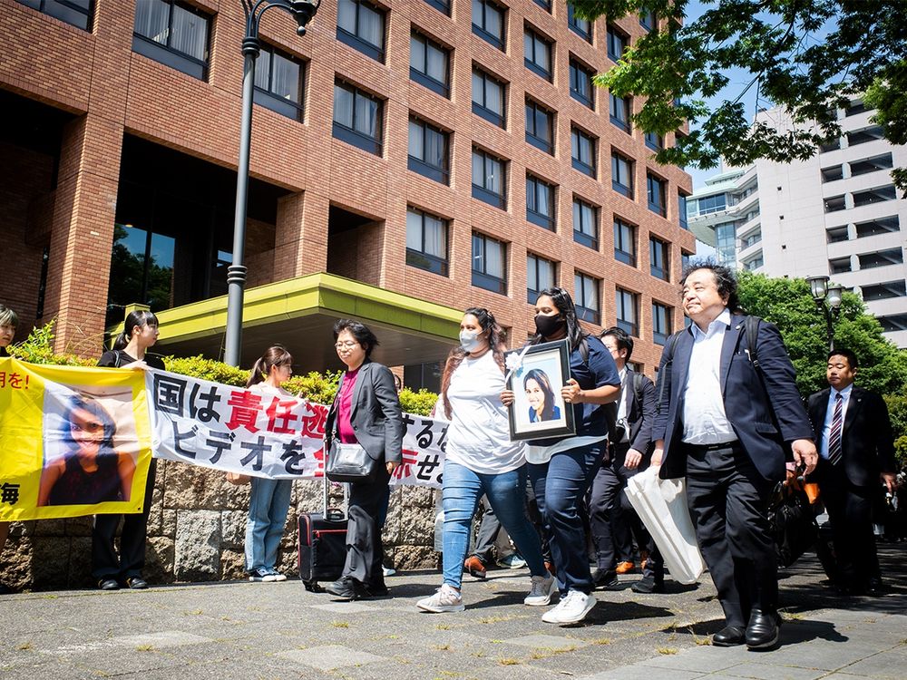 支援者たちに見送られながら、ウィシュマさんの妹のワヨミさん、ポールニマさんがウィシュマさんの遺影を掲げ、弁護士とともに名古屋地裁に入廷していく。佐藤慧撮影