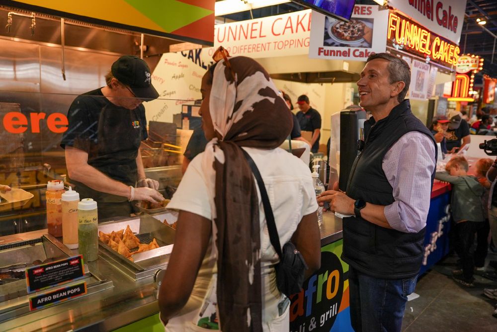 DNC Chair Ken Martin and Minnesota State Senator Zaynab Mohamed at a food booth during the Minnesota State Fair.