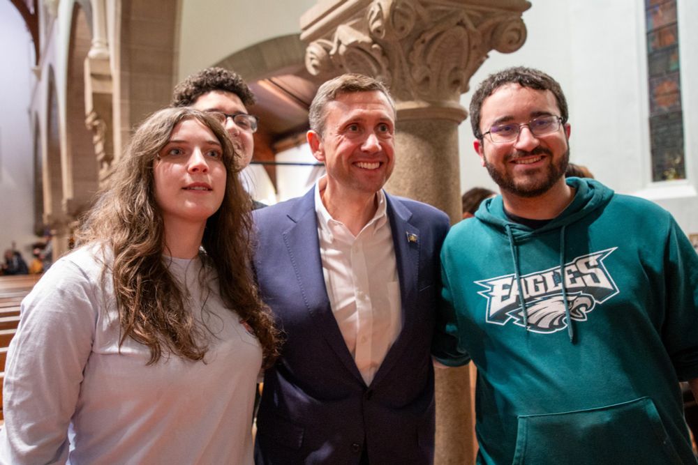 DNC Chair Ken Martin posing for a photo with two individuals at the town hall