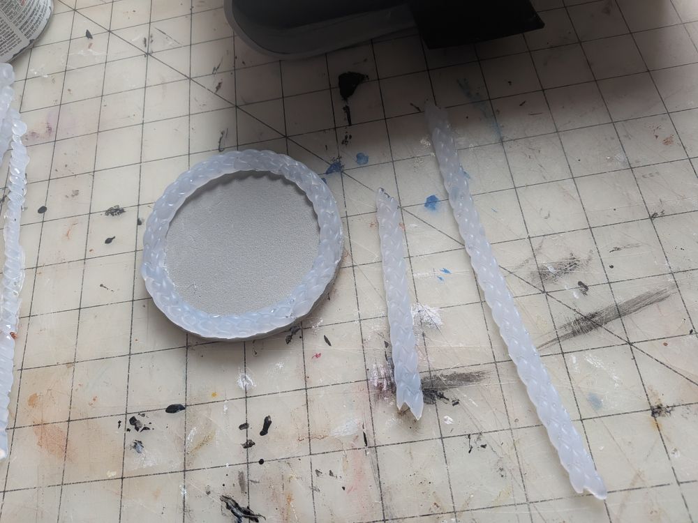 Updating the medallion with a better boarder. Lots of hot glue details on these books.

Foam disk with border made with silicone mold and hot glue. 