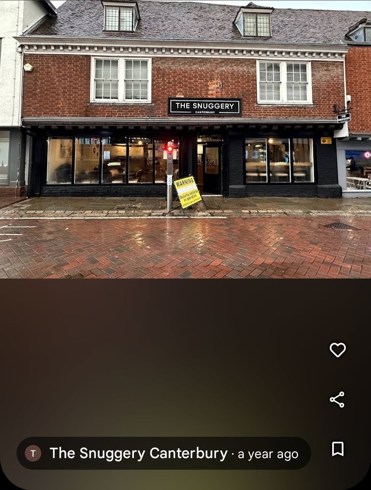 Google Maps photo of The Snuggery (a cafe) with a yellow sign in front. The caption says the photo was taken and posted a year ago.