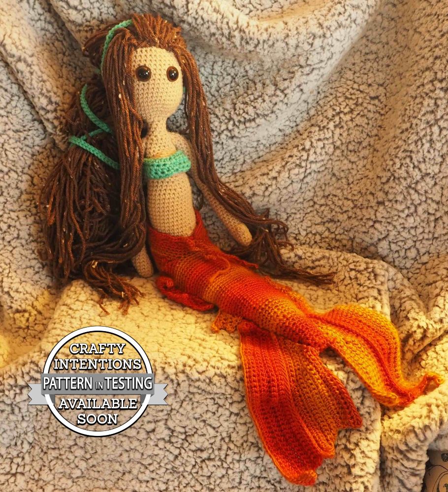 This doll is Themis from Thesalonika. She is made with olive skin colored yarn and has a slide on mermaid tail.
