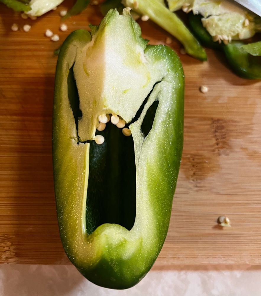 A cut green bell paper making a “face”