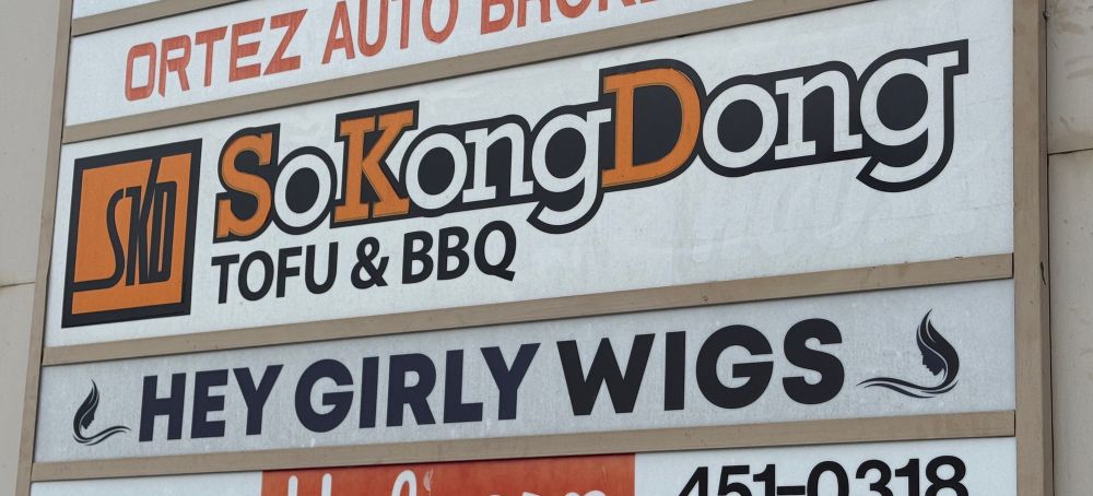 Shopping center sign highlighting two adjacent businesses:

SoKongDong
Tofu & BBQ

And

Hey Girly Wigs
