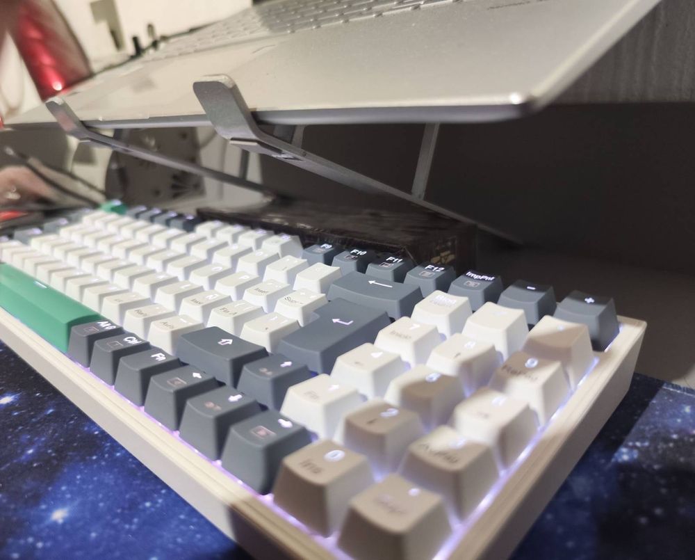 The laptop is held by a raiser, which is held by a dominoes box, which is pushed against the wall by the keyboard itself!