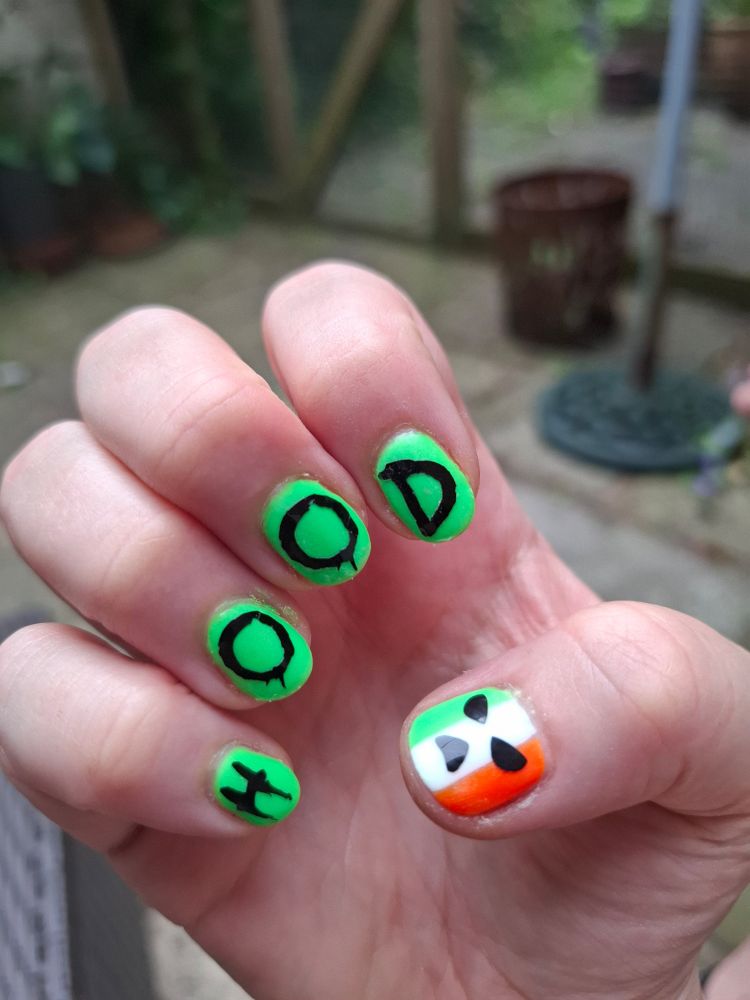 Hand with Irish flag and Kneecap logo nail art on thumb, green on other nails and "H.O.OD" on each fingernail