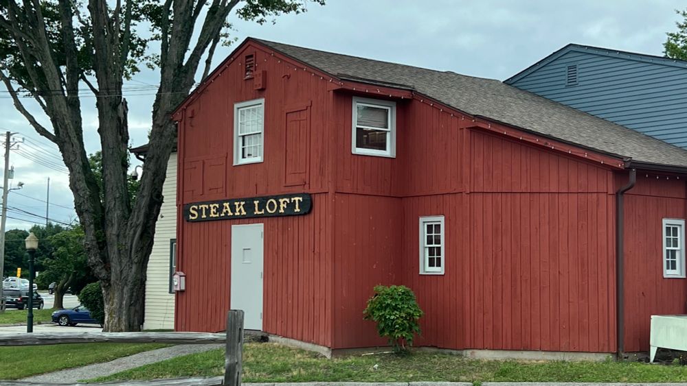 a red building adorned with the words STEAK LOFT
