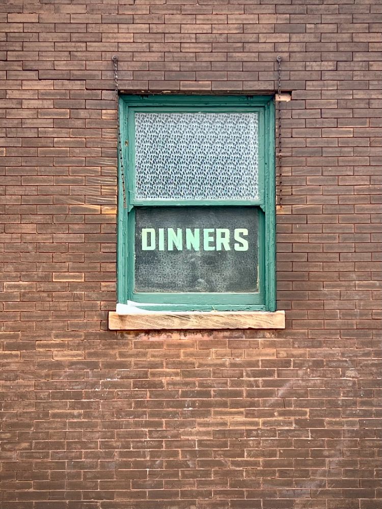 Tied house at 94th and Ewing. Word “dinners” is painted on the window.