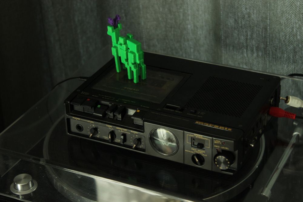 Closer 3/4 view of the tape player, with neon green deers on top.