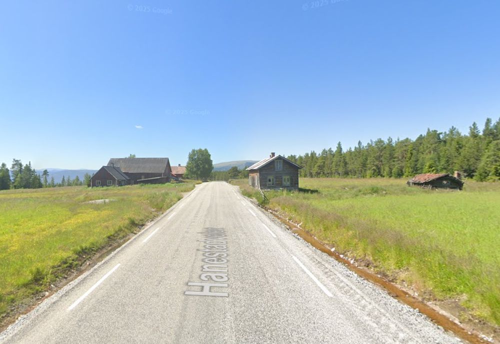 Bilete frå Google Street View frå ein veg som går gjennom eit gardstun, med bygningar på begge sider.