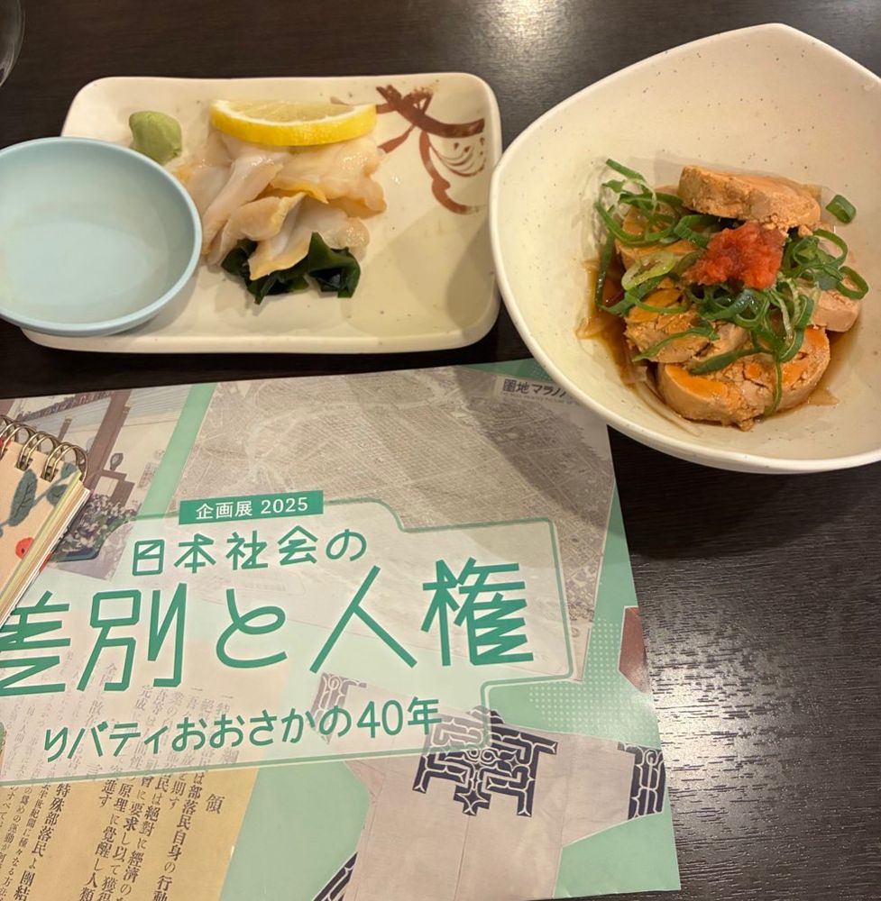 国際交流センターで開催してた差別と人権展のチラシと飲み屋の食べ物（つぶ貝とあん肝）