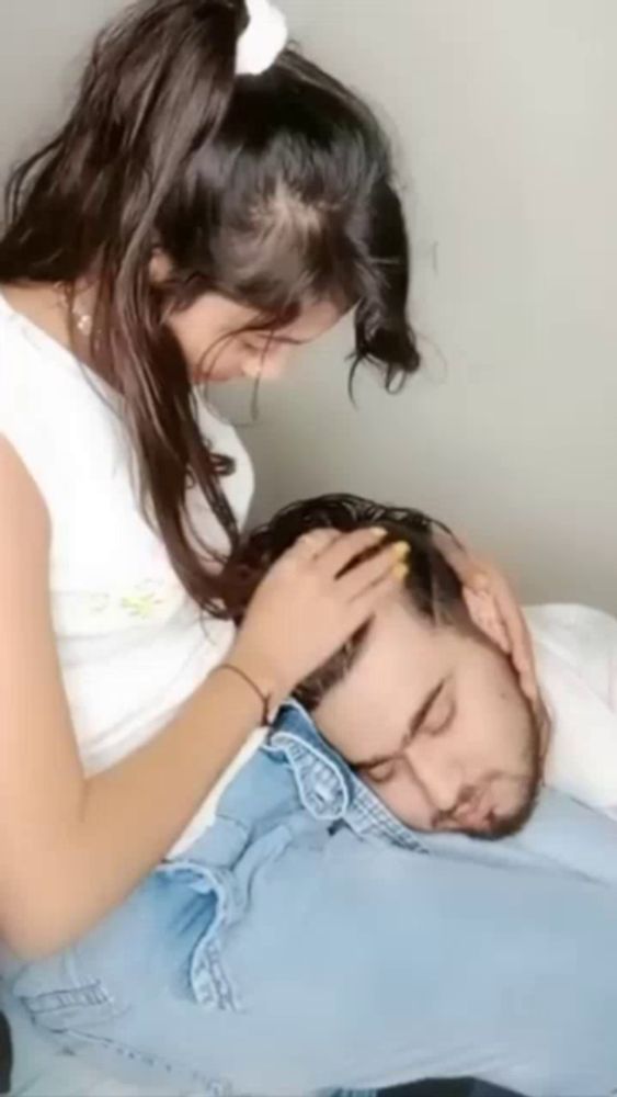 a woman is putting her hand on a man 's forehead